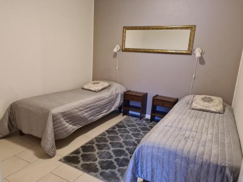 Zimmer mit 2 Betten, einem Spiegel und einem Teppich in der Unterkunft LeviBooking LeviStar II apt 309 in Levi