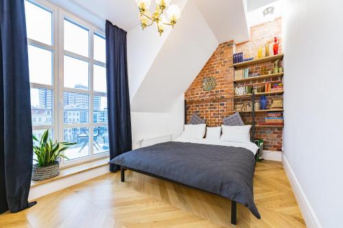a bed in a room with a brick wall at Retro Apartment Old Town in Wrocław