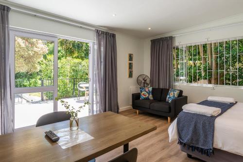 a bedroom with a bed and a table and a couch at Oak Manor in Cape Town