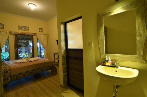 Uma Shanty Karangasem في كارانجاسيم: حمام مع حوض وسرير ومرآة