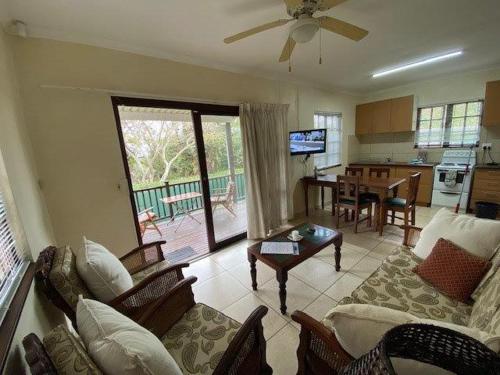 a living room with a couch and a table at Coral Cottage in Port Shepstone