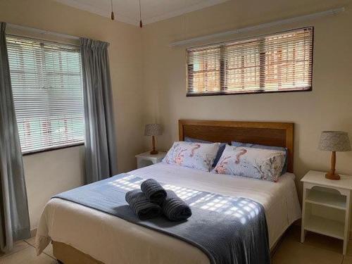 a bedroom with a bed with two towels on it at Coral Cottage in Port Shepstone