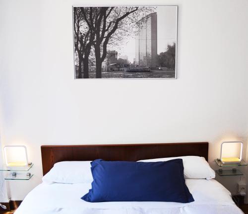 a bedroom with a blue pillow on a bed with two lamps at Room Inn in Milan