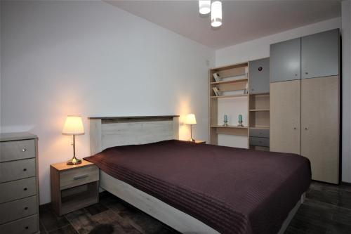 una camera con un grande letto e due lampade di Maria*s Apartment! a Cristian