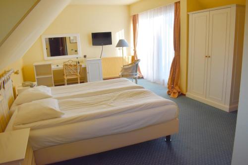 a hotel room with a bed and a desk at Fletcher Hotel-Restaurant Kasteel Erenstein in Kerkrade