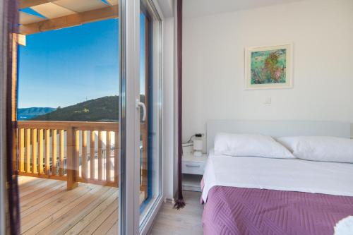 a bedroom with a bed and a balcony with a view at Camping Homes Grot in Gradac