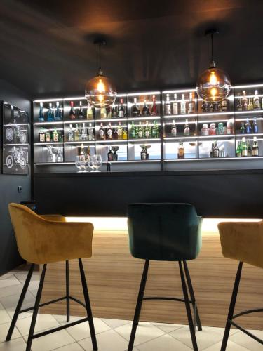 a bar with two chairs and a shelf with jars at Avila Park & SPA in Dziwnówek