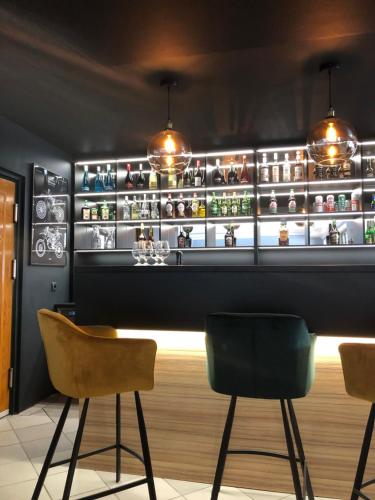 a bar with two chairs and a counter with shelves at Avila Park & SPA in Dziwnówek