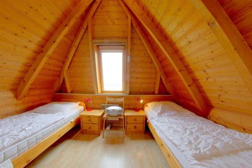 a bedroom with two beds in a wooden attic at Strandvogt 2 TR8 in Dorum Neufeld