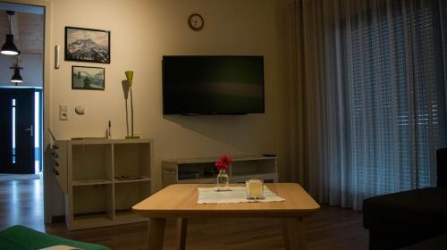 a living room with a coffee table and a flat screen tv at Die Pfalzherberge in Waldfischbach-Burgalben