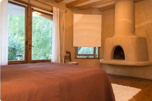 a bedroom with a large bed and a fireplace at Exquisita habitación en suite en el corazón de Chacras de Coria in Chacras de Coria