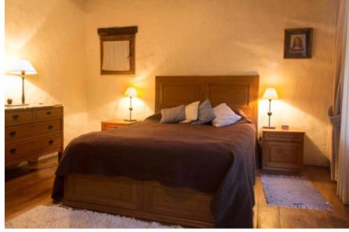 1 dormitorio con 1 cama con 2 mesitas de noche y 2 lámparas en Exquisita habitación en suite en el corazón de Chacras de Coria en Chacras de Coria