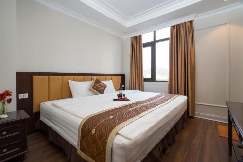 a bedroom with a large bed and a window at An Phú Nguyễn Hoàng Hotel in Hanoi