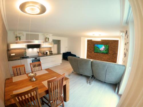 a living room and kitchen with a table and chairs at Antike & Modern Deluxe 2 mit Terrasse in Leipheim