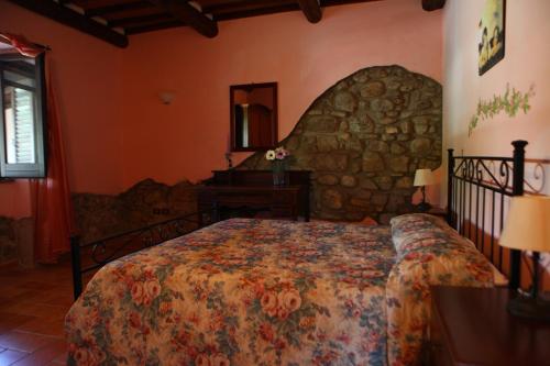 a bedroom with a bed and a stone wall at Agriturismo Il Pozzo in Casal Velino