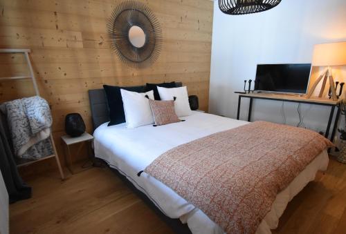 sypialnia z dużym łóżkiem i drewnianą ścianą w obiekcie VAUJANYLOCATIONS - Saphir 04 w mieście Vaujany