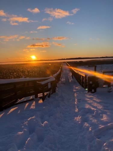 a snowy path in the snow with the sunset in the background at Avila Park & SPA in Dziwnówek