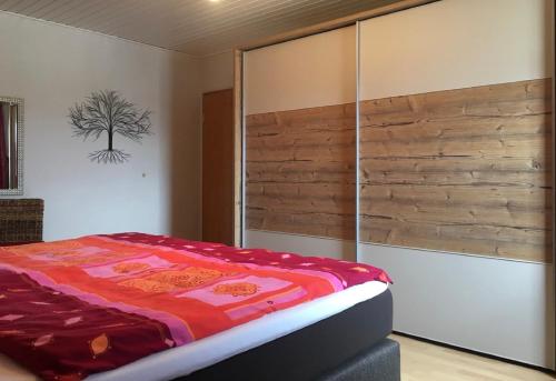 a bedroom with a bed and a wooden wall at Ferienwohnung Evelyn und Reinhard Himmler in Pleinfeld