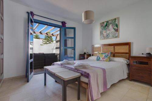 プラヤ・ブランカにあるVilla Alegranzaのベッドルーム1室(ベッド1台付)、スライド式ガラスドアが備わります。
