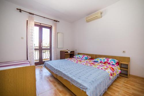 a bedroom with a bed and a large window at Apartments and Rooms Drpić in Splitska