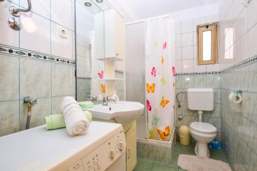 łazienka z umywalką, toaletą i prysznicem w obiekcie Apartments Duje Zadar w mieście Zadar