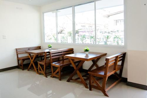 two tables and chairs in a room with a window at วรรณ เพลส Won Place in Khon Kaen