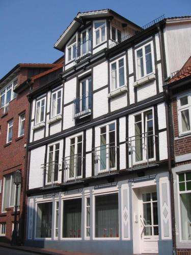 a white and black building with windows and balconies at Das Stader Apartment in Stade