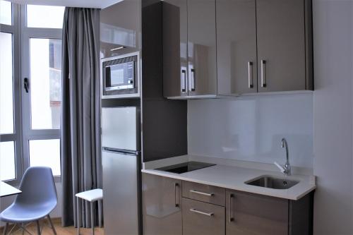 a kitchen with a refrigerator and a sink at Atlantic Apartments in Las Palmas de Gran Canaria