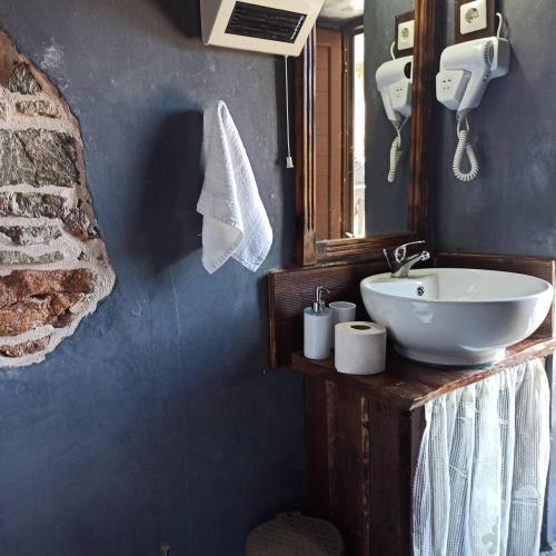 a bathroom with a sink and a mirror at Areti's Traditional house in Apóllona