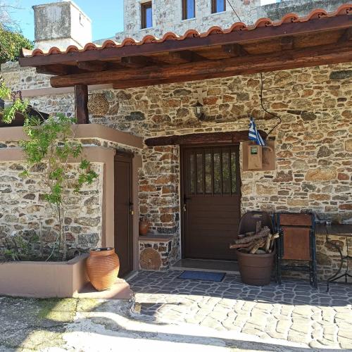 a stone house with a door and a vase at Areti's Traditional house in Apóllona