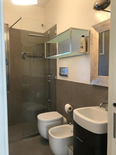 a bathroom with a toilet and a sink and a shower at Venice Homes & Holidays in Venice