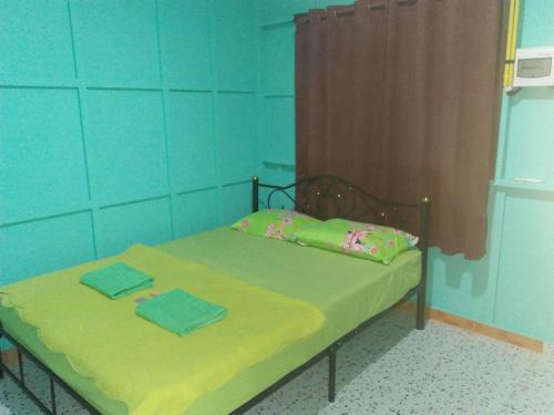 a bedroom with a bed with two towels on it at บ้านพักกลางนา in Amphoe Sawang Daen Din