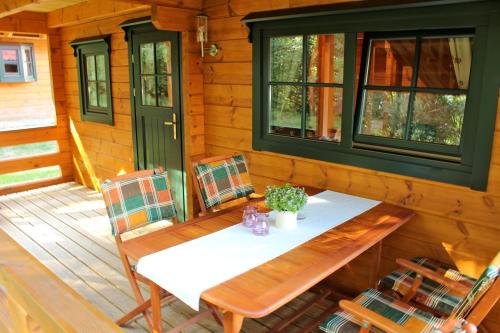 einen Holztisch und Stühle auf der Veranda einer Hütte in der Unterkunft Ferienpark Arber in Zwiesel