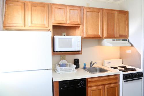 a kitchen with wooden cabinets and a white refrigerator at Quality Inn Boardwalk in Ocean City