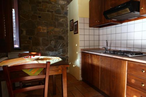 a kitchen with a table and a stove top oven at Agriturismo Il Pozzo in Casal Velino