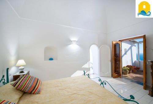 a white room with a bed and a mirror at Casa Elisabetta in Praiano
