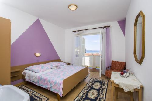 a bedroom with a bed and a purple wall at Rooms Padovan in Banjol