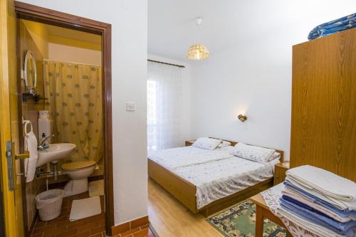 BanjolにあるRooms Padovanのベッドルーム(ベッド1台、シンク、トイレ付)
