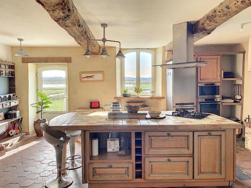 - une cuisine avec un grand îlot en bois dans l'établissement La Cricque, à Cricqueville-en-Bessin