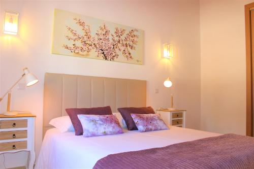 a bedroom with a white bed with two pillows at Quinta das Alfambras in Aljezur