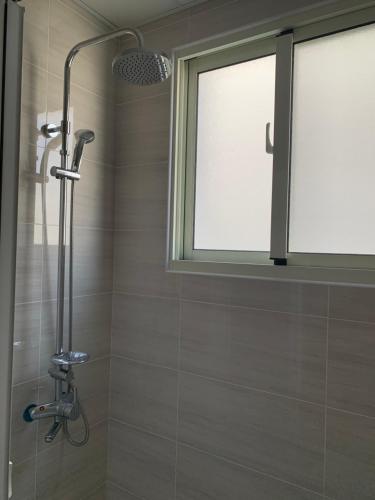 a shower in a bathroom with a window at AwIN’s Homestay in Ruisui