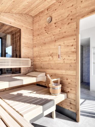 a sauna with wooden walls and benches at Dolomiten Residenz - Sporthotel Sillian in Sillian
