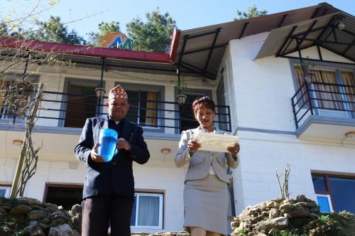 a man and a woman standing in front of a house at Hotel Mount Paradise in Nagarkot