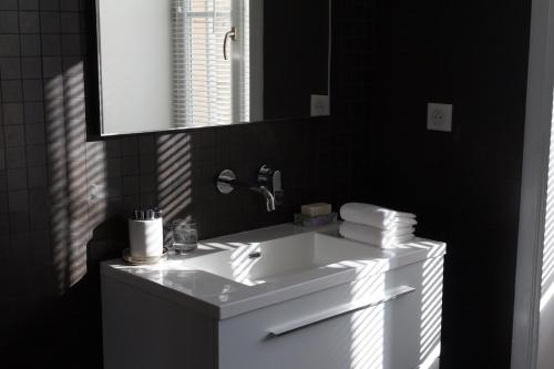 une salle de bain avec un lavabo blanc et un miroir dans l'établissement MA CHAMBRE A SAINT AMOUR, à Saint-Amour-Bellevue