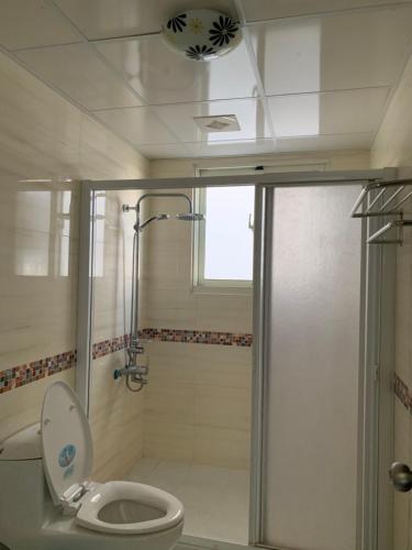 a bathroom with a toilet and a shower with a glass door at AwIN’s Homestay in Ruisui