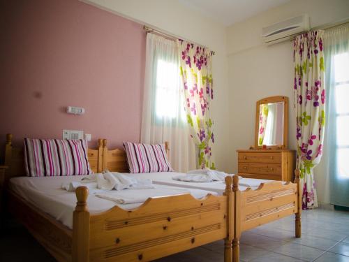 een slaapkamer met een groot houten bed en een spiegel bij Portokali Apartments in Chersonissos