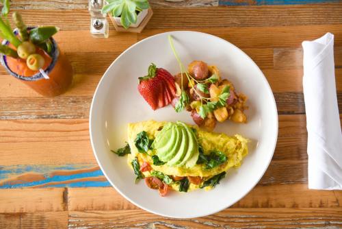 a plate of omelet with a strawberry and avocado at The Cliffs Hotel and Spa in Pismo Beach