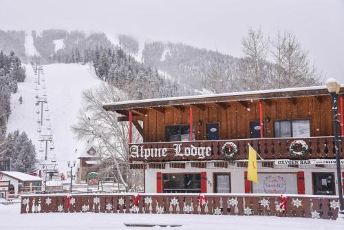 Alpine Lodge Red River في ريد ريفر: مبنى مع كوخ تزلج في الثلج