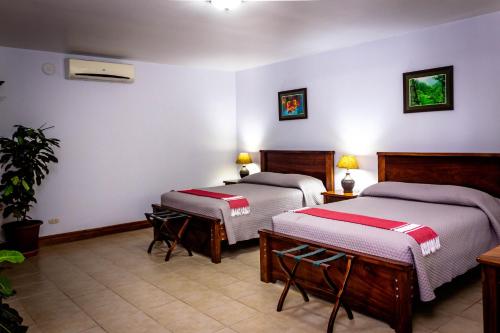 a hotel room with two beds and two lamps at Jaco Hotel DoceLunas in Jacó