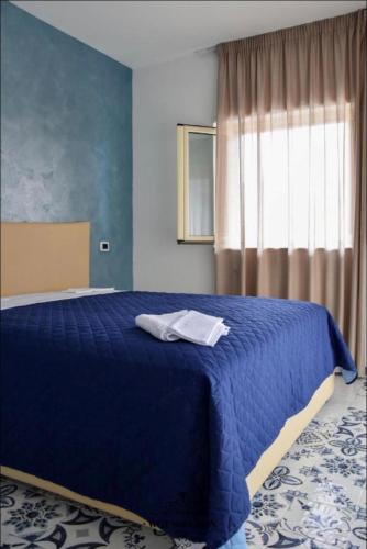a blue bedroom with a blue bed with a window at Samuel Fish in Bagnara Calabra